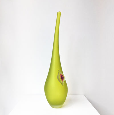 Vase en verre vert avec une figue.