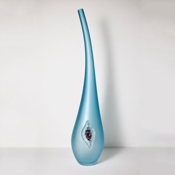 Vase en verre bleu avec une figue.