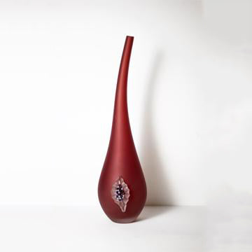 Vase en verre rouge avec une figue.