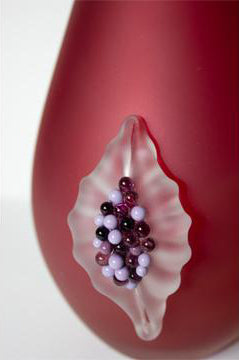 Vase en verre rouge avec une figue.
