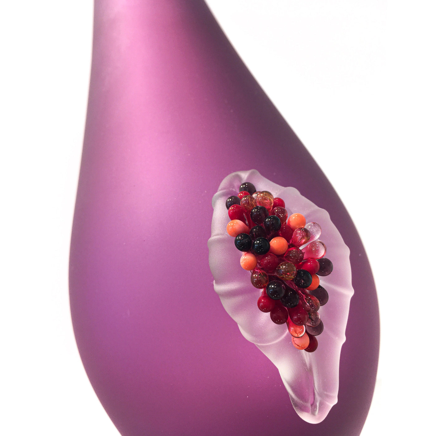 Vase en verre mauve avec une figue.
