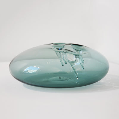Sculpture d'une pastille en verre bleu acier