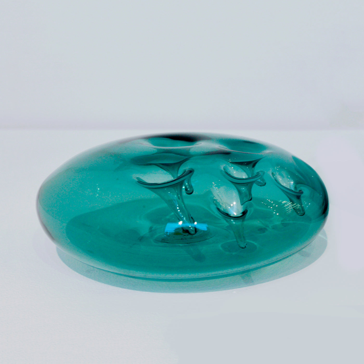Sculpture d'une pastille en verre bleu acier