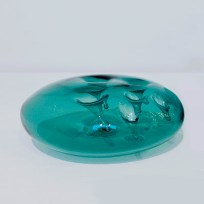 Sculpture d'une pastille en verre bleu acier