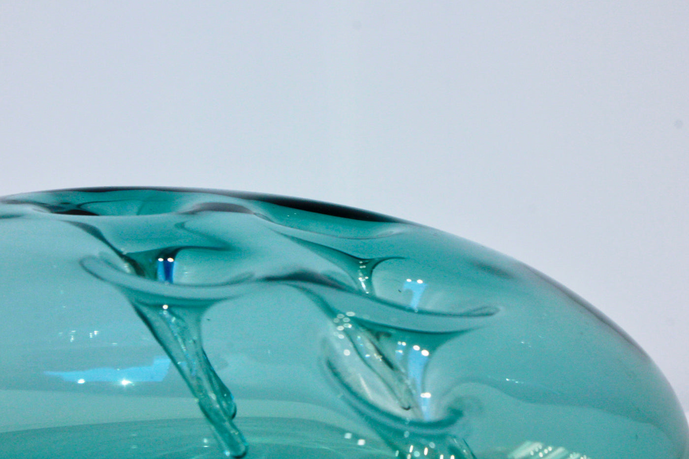 Sculpture d'une pastille en verre bleu acier