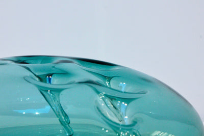 Sculpture d'une pastille en verre bleu acier