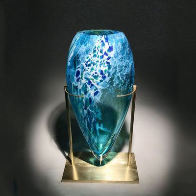 Sculpture d'un vase en verre soufflé travaillé à froid sur une base en laiton réalisée par l'artiste Maryse Chartrand de Sutton, Québec, Canada.