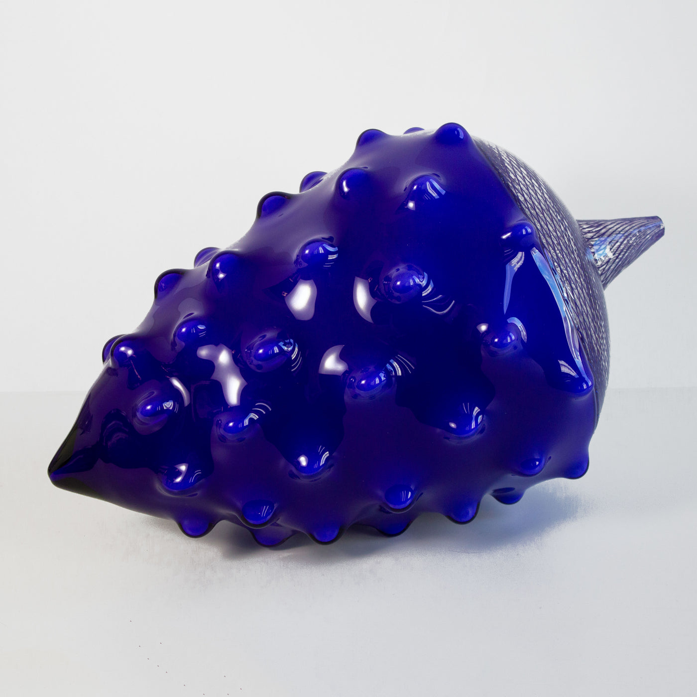 Sculpture en verre soufflé bleu de la forme d'une noix.