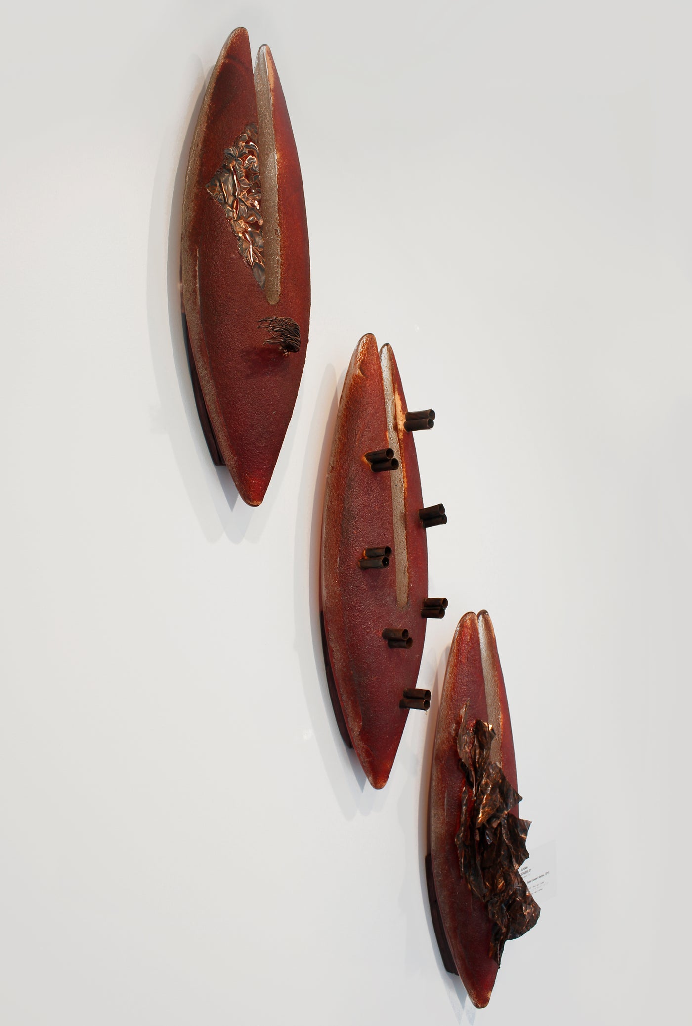 Ensemble de sculptures murales en verre rouge et cuivre.