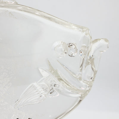 Sculpture en verre d'un poisson soutenu par une structure en métal.